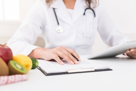 Doctor nutritionist making personal diet plan in hospital, closeupの写真素材