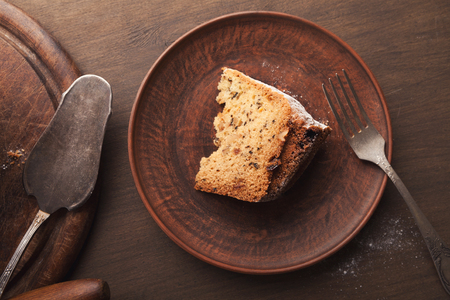 Slice of easter cake on wooden plate with forkの写真素材