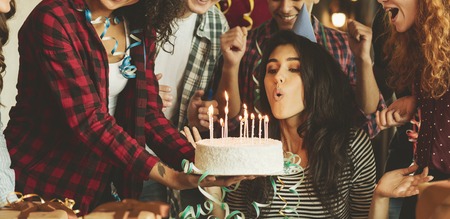 Friends making surprise with cake and canles for a birthday girl. Surprise birthday party conceptの写真素材