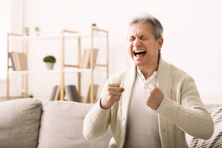 Stressed senior man shouting with aggressive expression at home, copy spaceの写真素材