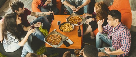Friends having party, enjoing pizza and drinks.の写真素材