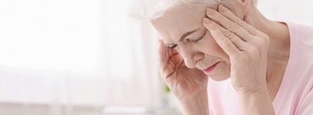 Stressed senior woman suffering from headache, healthcare concept, panorama with empty spaceの写真素材