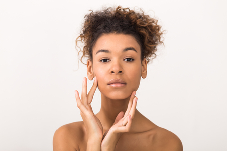 Natural beauty portrait. African-american woman looking at camera over light backgroundの写真素材