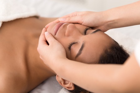 Spa face massage. Woman getting spa treatment at beauty salonの写真素材