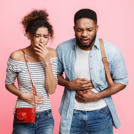 African-american couple suffering from food poisoning, having stomach ache, cropの写真素材