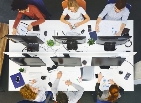 Business young multiethnic team working and planning start up in modern office, top view