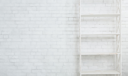 White wooden rack on white brick wall textured background, copy spaceの写真素材