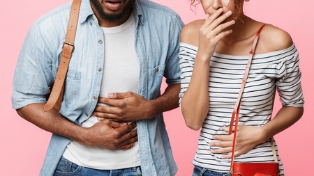 Tourists suffering from food poisoning, having stomach ache, pink background, cropの写真素材