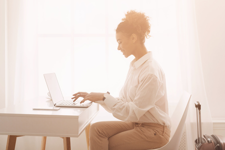 Staying connected anytime. Businesswoman working on laptop in hotel roomの写真素材