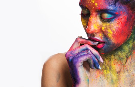 Thoughtful woman with creative colorful makeup biting her nails, white background with free space