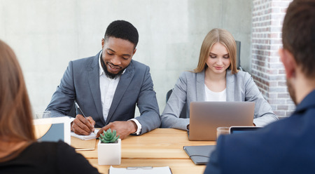 Hr managers interviewing job applicants, making notes and listening them in office