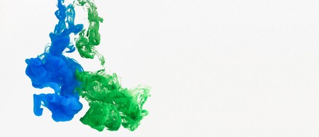 Motion of color drops underwater on white background, copy spaceの写真素材