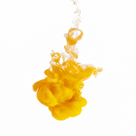Yellow paint swirling underwater on white background. Abstract design background conceptの写真素材