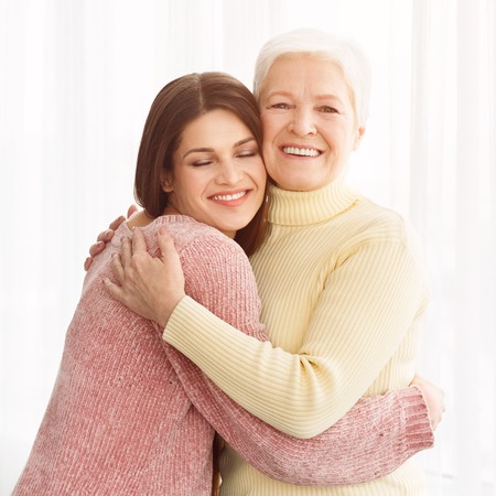 Cute young daughter embracing her mother with love, crop