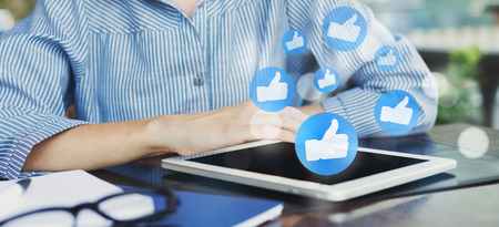 Woman using tablet with social media notification icons, panorama