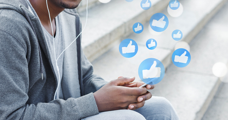 Social network likes. Man using smartphone, playing social mediaの写真素材