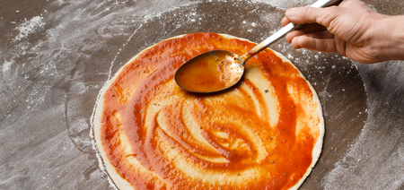 Chef cooking Italian pizza, adding and spreading sauce, panoramaの写真素材