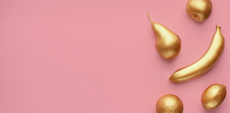 Golden fruits collage on pink background, copy space, top viewの写真素材