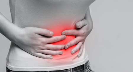 Woman holding hands on stomach, suffering from abdominal pain having food poisoning, gastritis....