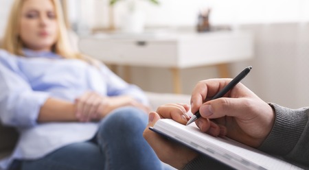 Professional psychotherapist taking notes, listening to female patient problems, panoramaの写真素材