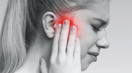 Tinnitus. Closeup up profile of sick woman having ear pain, touching her painful head, monochrome...