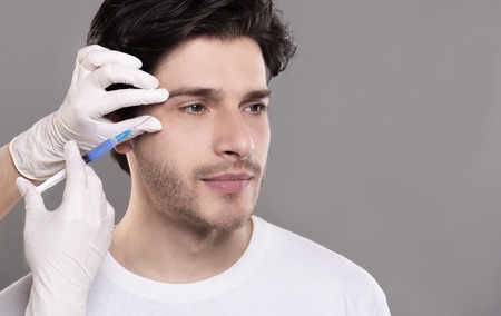 Beauty injection for men. Millennial guy getting surgery filling of facial wrinkles, empty space