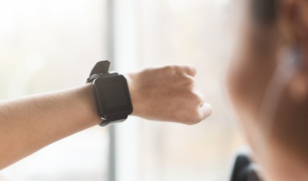 Girl using sport smart watch, doing cardio exercise on treadmill in gymの写真素材