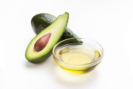 Fresh avocado and oil in glass bowl on white background. Vegetable fats conceptの写真素材