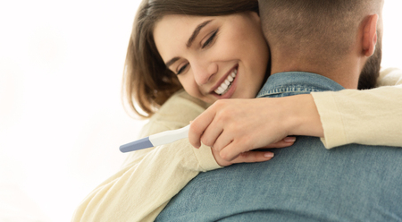 Im Pregnant. Couple Happy About Positive Results Of Pregnancy Test, Hugging Each Otherの写真素材