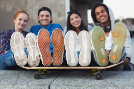 Friends Skaters. Urban trendy diverse teenagers with legs on skate, empty spaceの写真素材