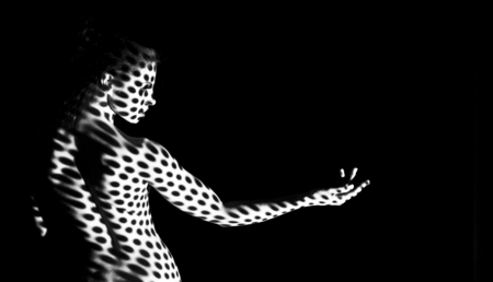 Play of light and shadows. Naked woman with pattern on her nude body, empty spaceの写真素材