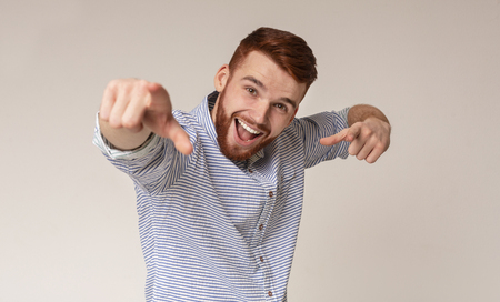 You are special! Cool caucasian man suggest challenge at camera, choosing to compete, beige studio backgroundの写真素材