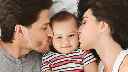 Beloved baby. Parents kissing their cute infant, closeup, panoramaの写真素材