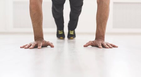 Unrecognizable sporty man standing in plank in studio, panorama, crop, copy spaceの写真素材
