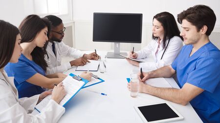 Online Education. Doctor And Interns Having Lecture And Taking Notes In Meeting Roomの写真素材