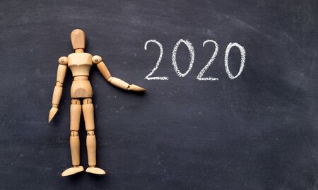 2020 concept. Wooden mannequin with handwriting text on chalk board, panorama, copy spaceの写真素材
