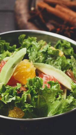 Close up of fresh fruits and vegetables salad in copper bowl, vertical panoramaの写真素材