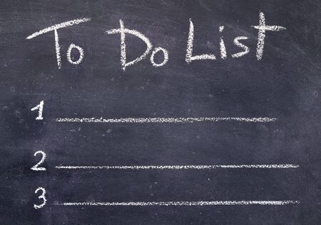 Planning concept. Handwriting to do list with chalk on black board background, copy spaceの写真素材