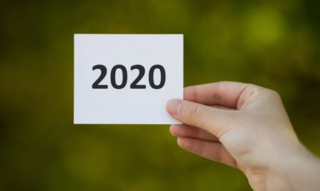 Planning summer 2020. Close up of White paper sheet in woman hand outdoor, panorama, free spaceの写真素材