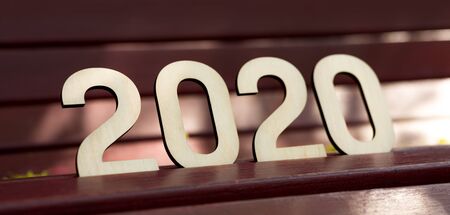 Summer 2020. Big wooden numbers standing on bench in park, panorama, copy space