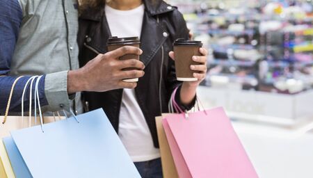 African american couple with lot of shopping bags and coffee to go walking by shopping mall, copy spaceの写真素材