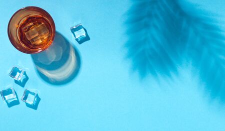 Tropical refreshing cocktail with ice cubes on blue background, panorama, copy spaceの写真素材