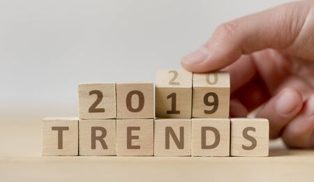 New trends concept. Woman hand turning over wooden blocks with text from 2019 to 2020 on background, panoramaの写真素材