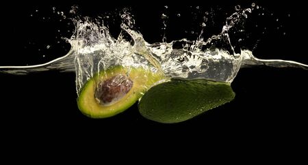 Fresh avocado and clean water splash, black panorama backgroundの写真素材