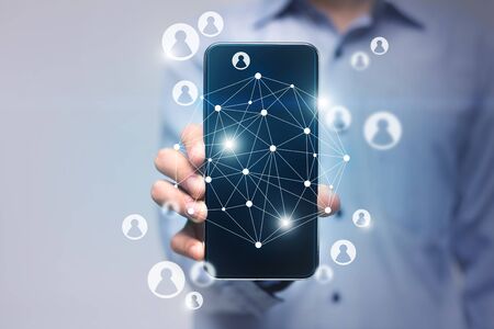 Digital marketing media. Businesswoman hand holding mobile phone with VR icon diagram of worldwide connectionの写真素材