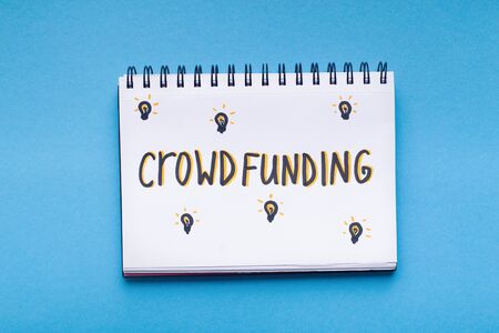 Crowdfunding concept. Handwriting red text in notepad on blue background, panorama, copy spaceの素材 [FY310126094341]