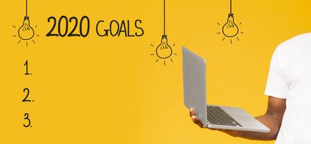 2020 goals. Blank checklist and african guy holding laptop, yellow panoramaの写真素材