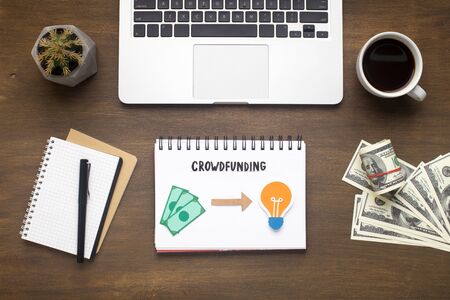 Business concept. Office table with laptop, money and notepad with crowdfunding plan, panoramaの写真素材