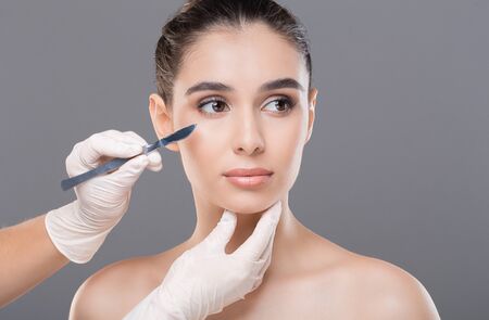 Cosmetologist preparing young woman for plastic surgery procedure, free spaceの写真素材