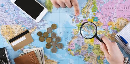 Searching trip concept. Two friends trying to find a country where to go with magnifying glass, panoramaの写真素材